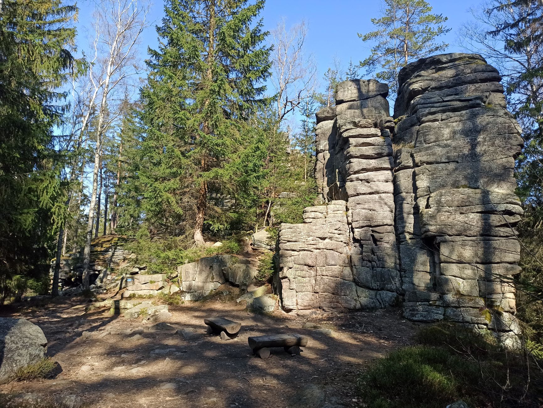 Explore towering rock formations and lush forests in Karkonosze, Poland.