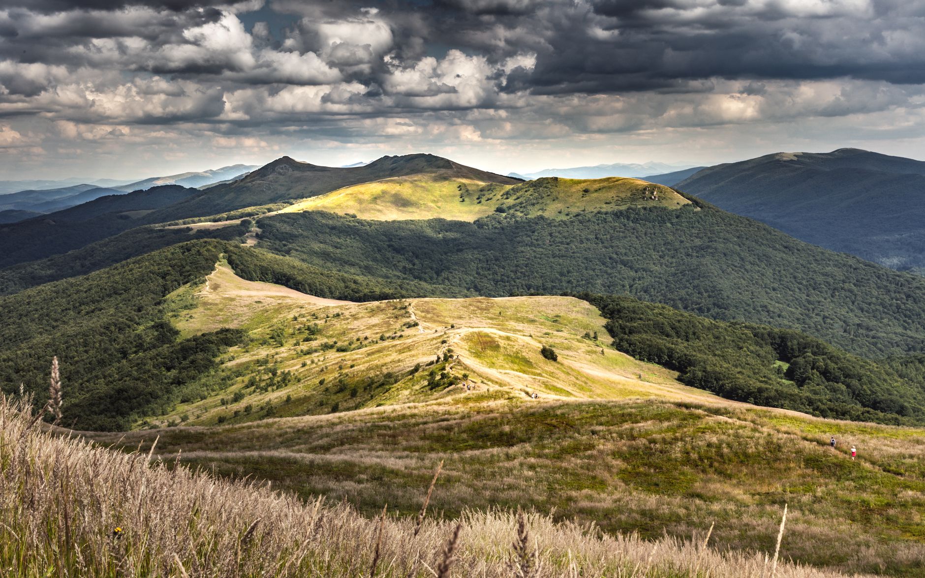 Breathtaking view of Bieszczady Mountains under a dramatic sky in Podkarpackie, Poland.