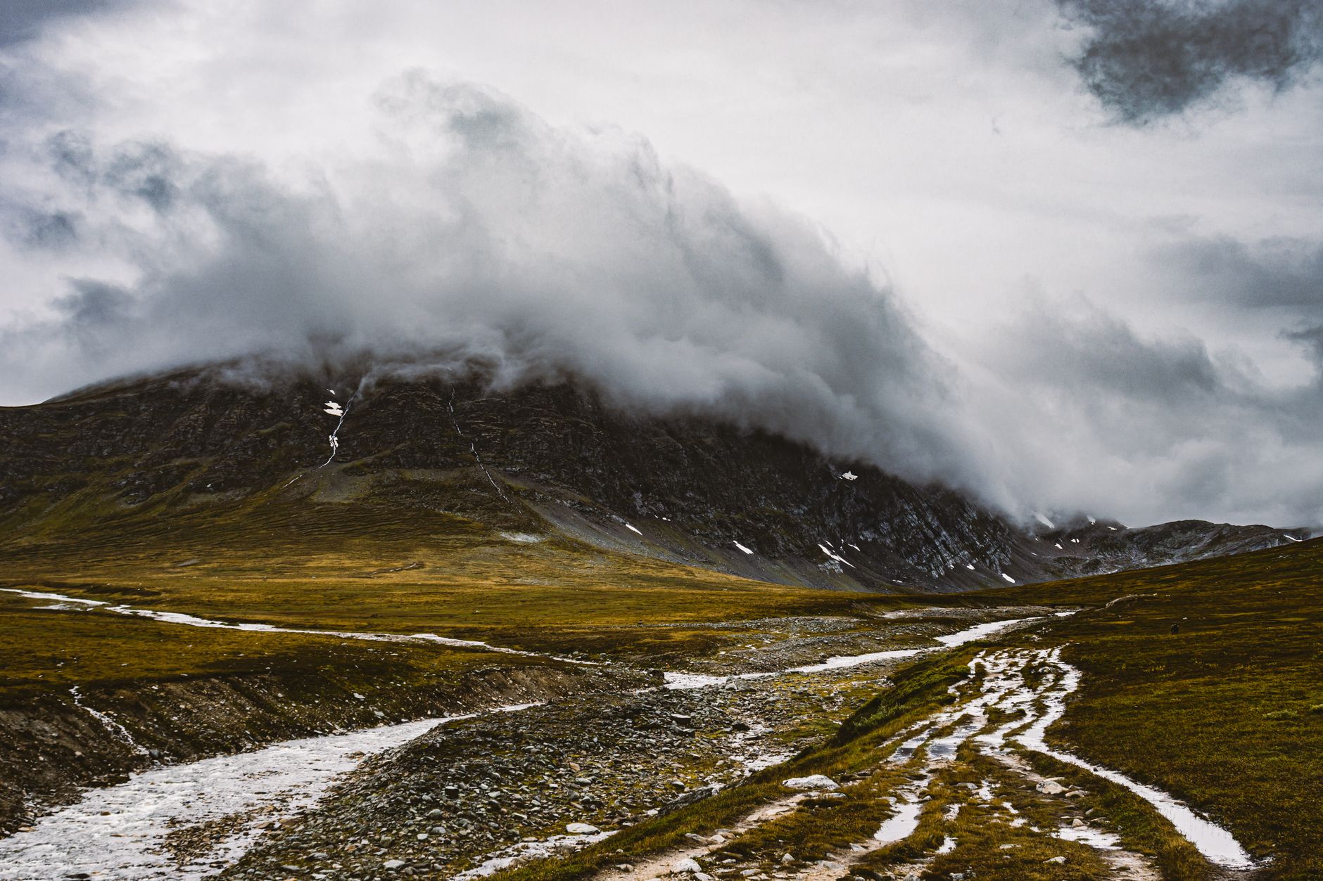 Breathtaking mountain scene with dramatic clouds and rugged terrain, perfect for adventure and nature enthusiasts.
