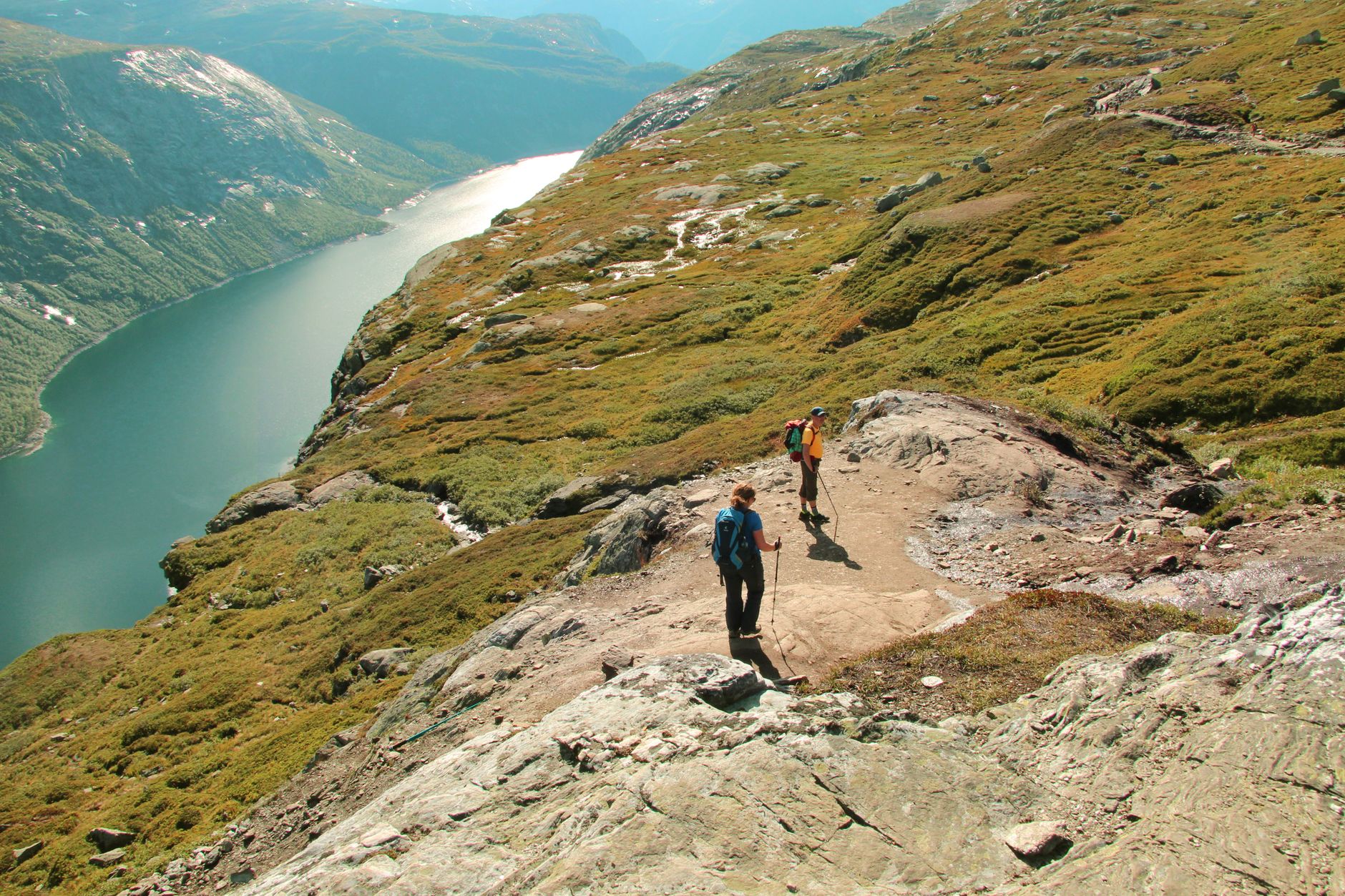 Explorers enjoy a hiking trail along scenic mountains and river views.