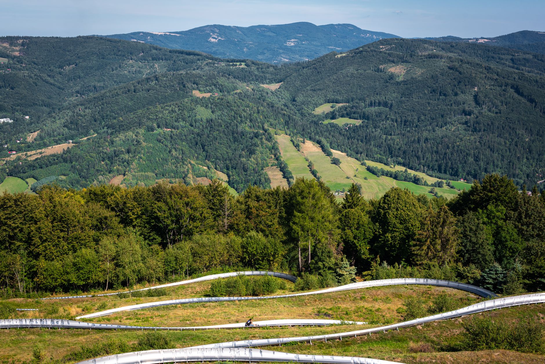 Breathtaking aerial view of lush green mountains and winding paths in Poland.
