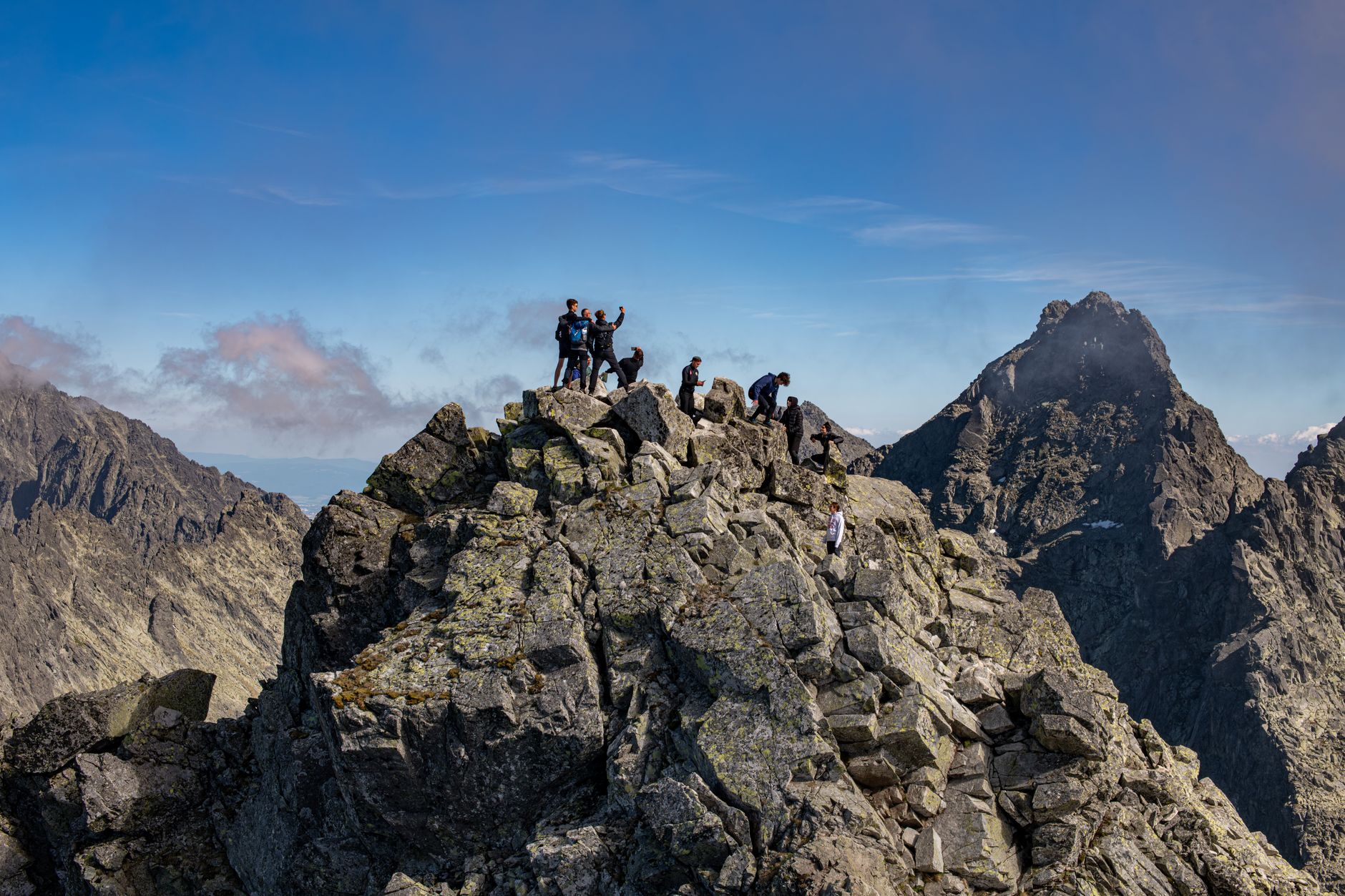 Group of hikers enjoy breathtaking views from Rysy mountain summit, Tatras.