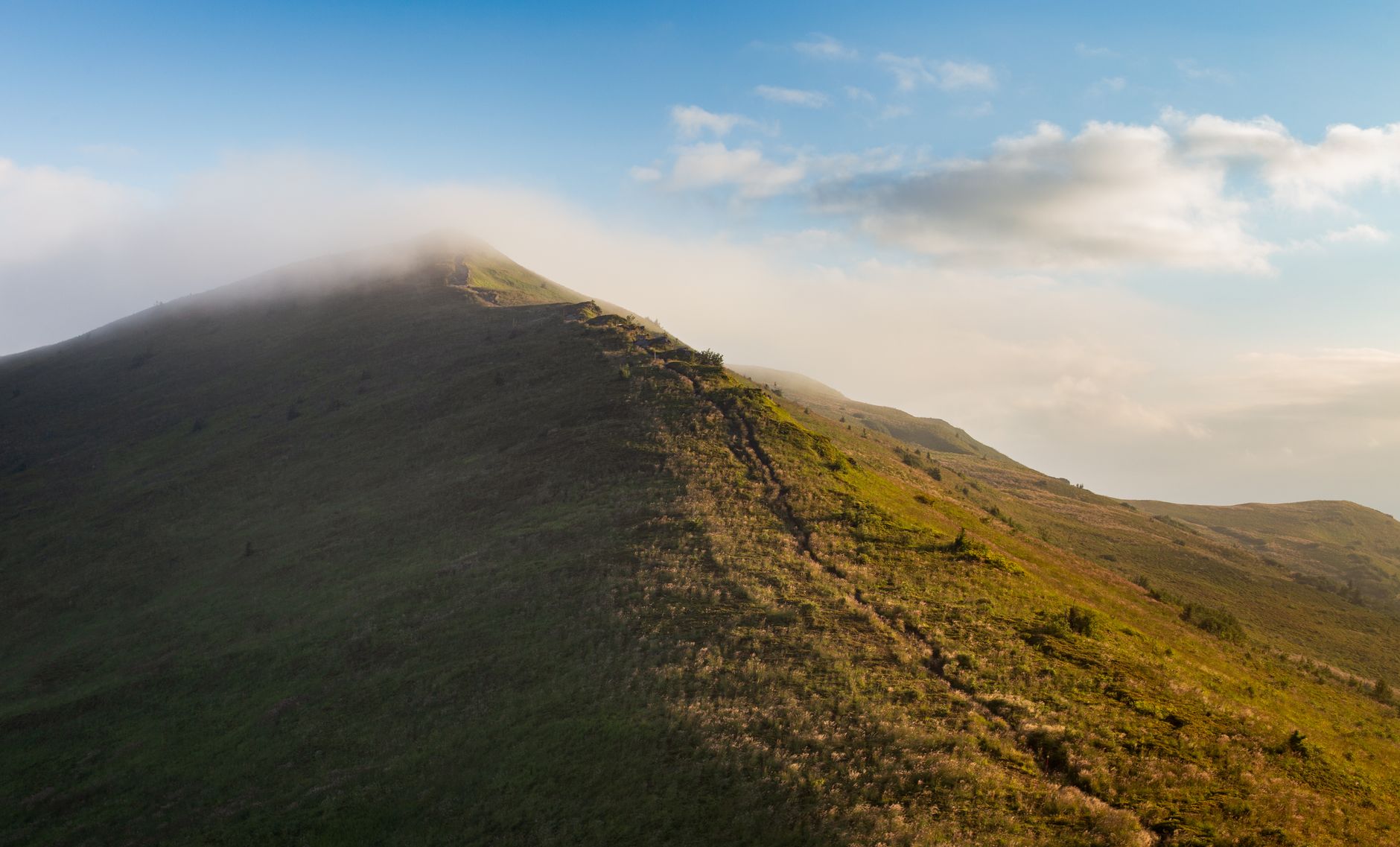 Breathtaking view of a misty mountain ridge in Bieszczady at sunrise, perfect for hiking enthusiasts.