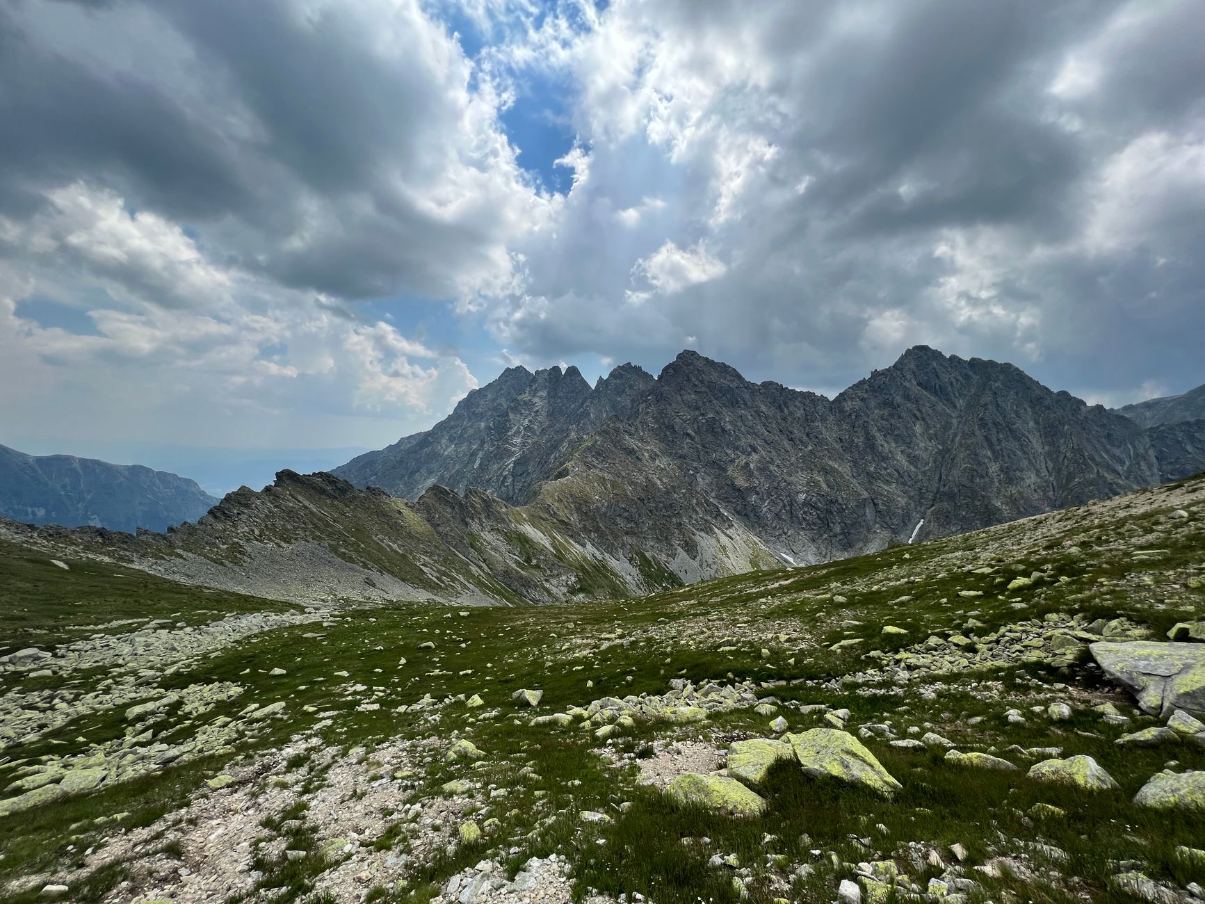 Scenic view of the rugged High Tatra Mountains under a dramatic cloudy sky, perfect for nature enthusiasts.