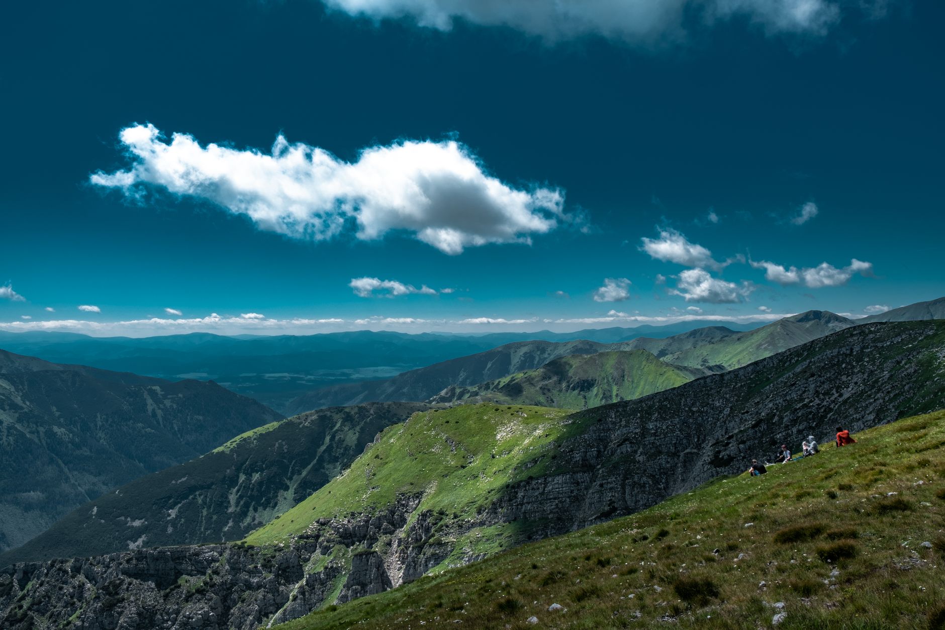 Scenic landscape of the Tatra mountains with lush green hills and blue sky, perfect for nature lovers.