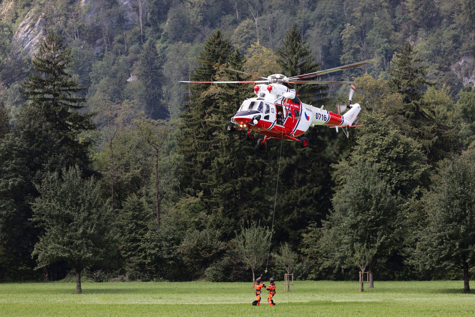 Helicopter conducting a rescue operation in Glarus Nord, Switzerland's scenic mountains.