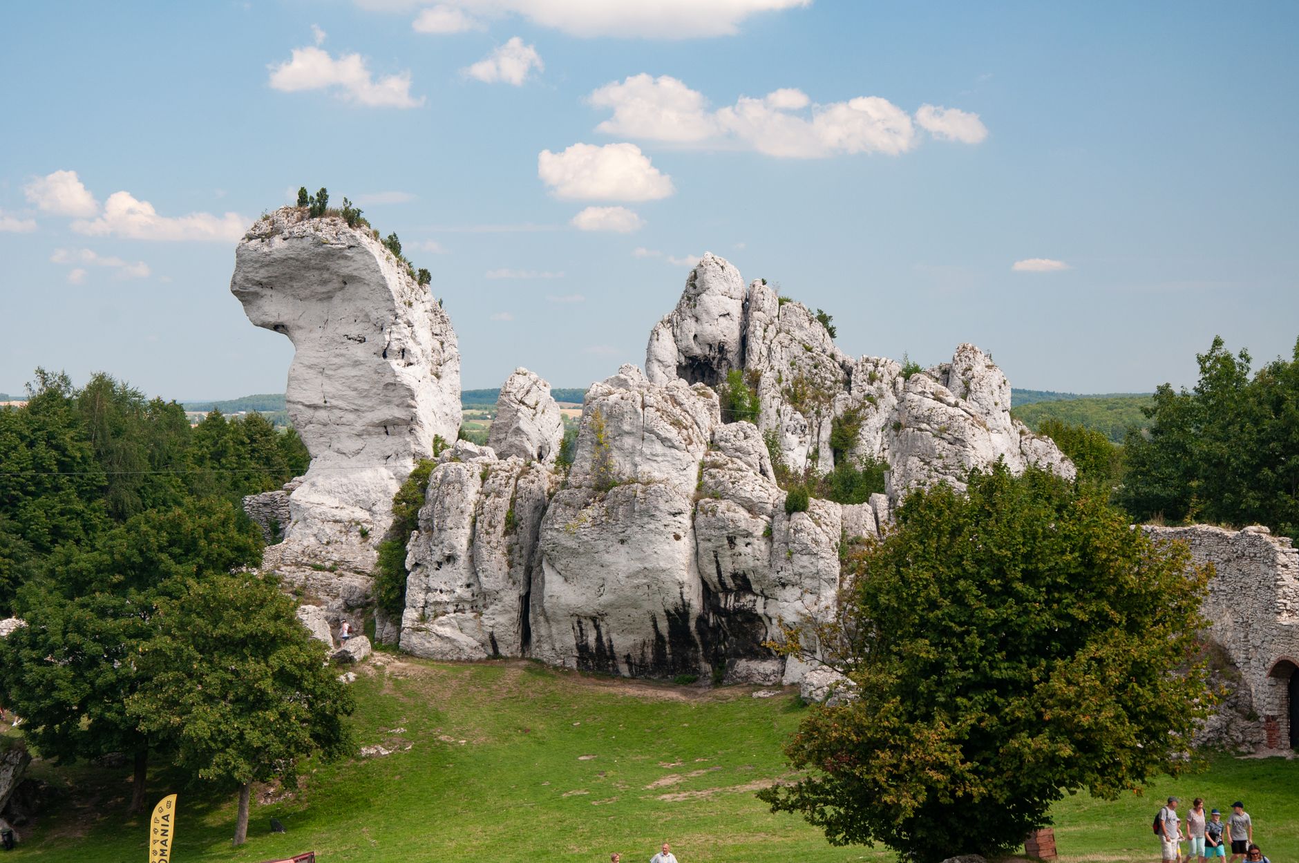 Explore the breathtaking Ogrodzieniec Castle ruins set against a clear sky in Poland's picturesque landscape.
