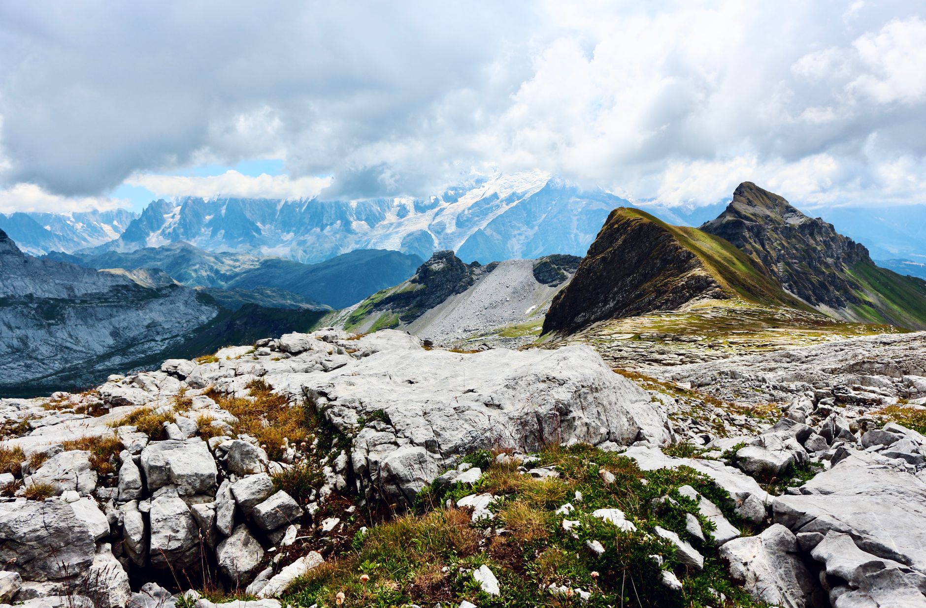 Breathtaking view of Mont Blanc from Chamonix with rocky foreground and stunning cloudy sky.