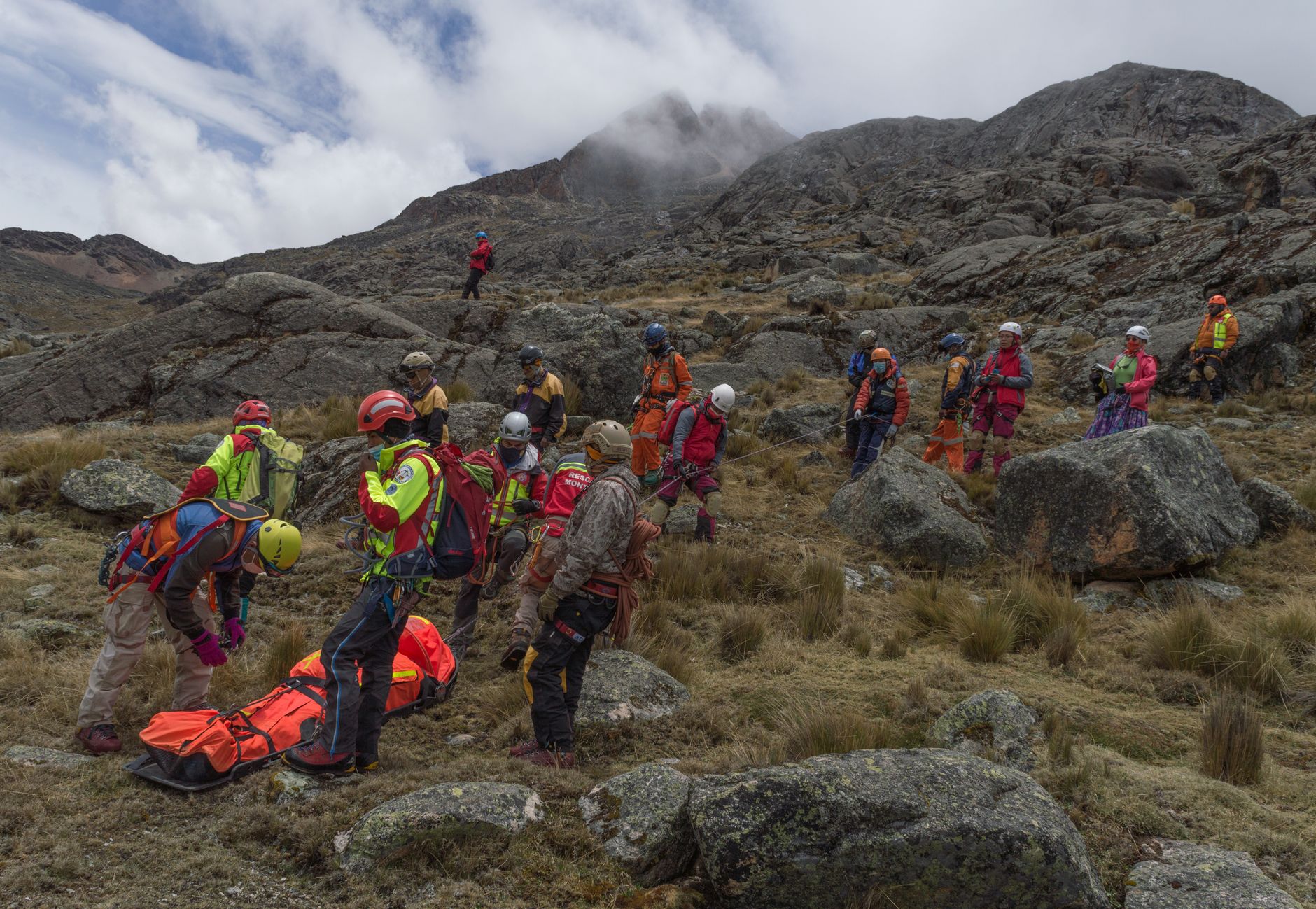 Rescue team conducting a mountain rescue mission, equipped with safety gear.