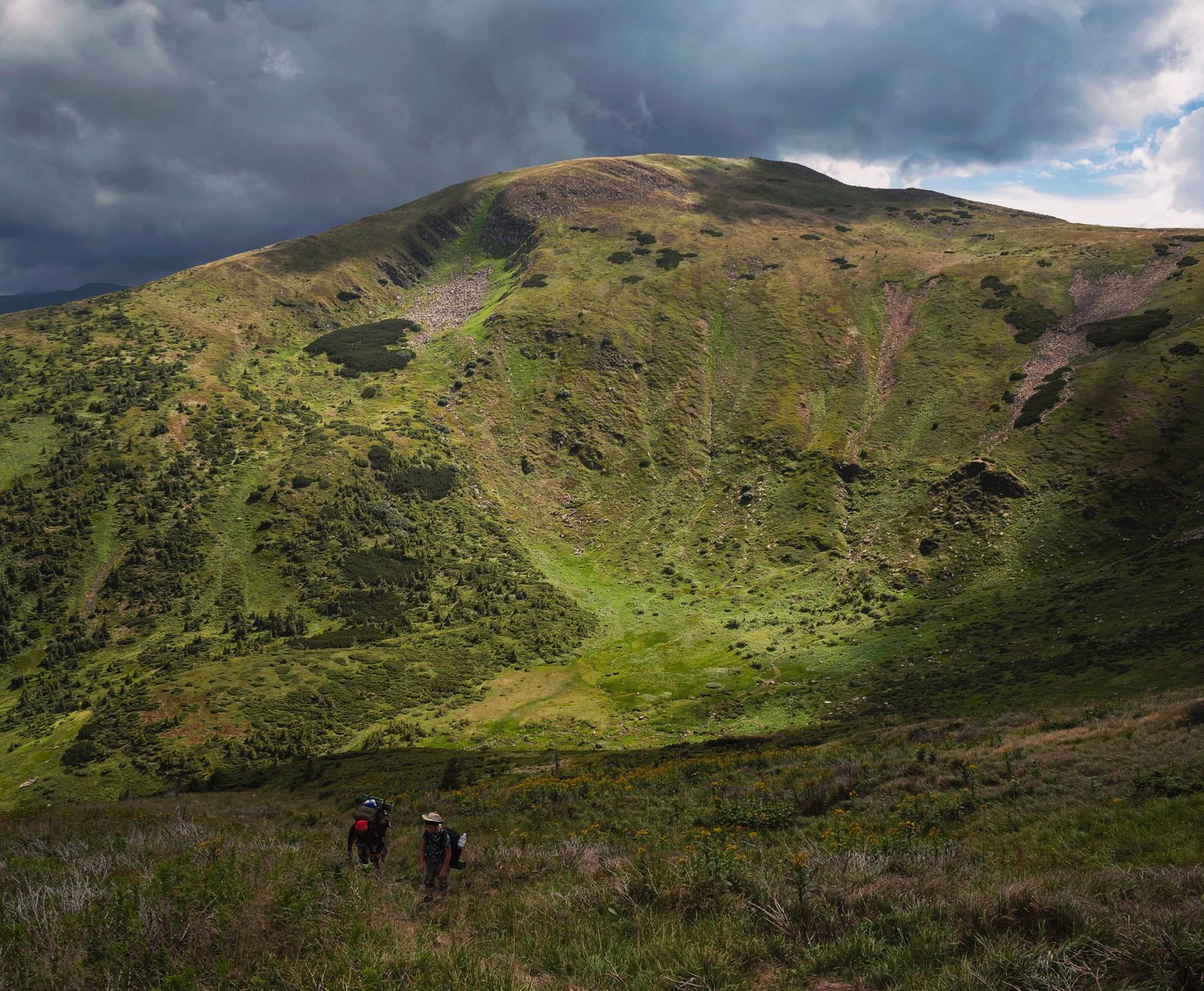 Explore the stunning landscapes of the Carpathian Mountains under a dramatic cloudy sky.