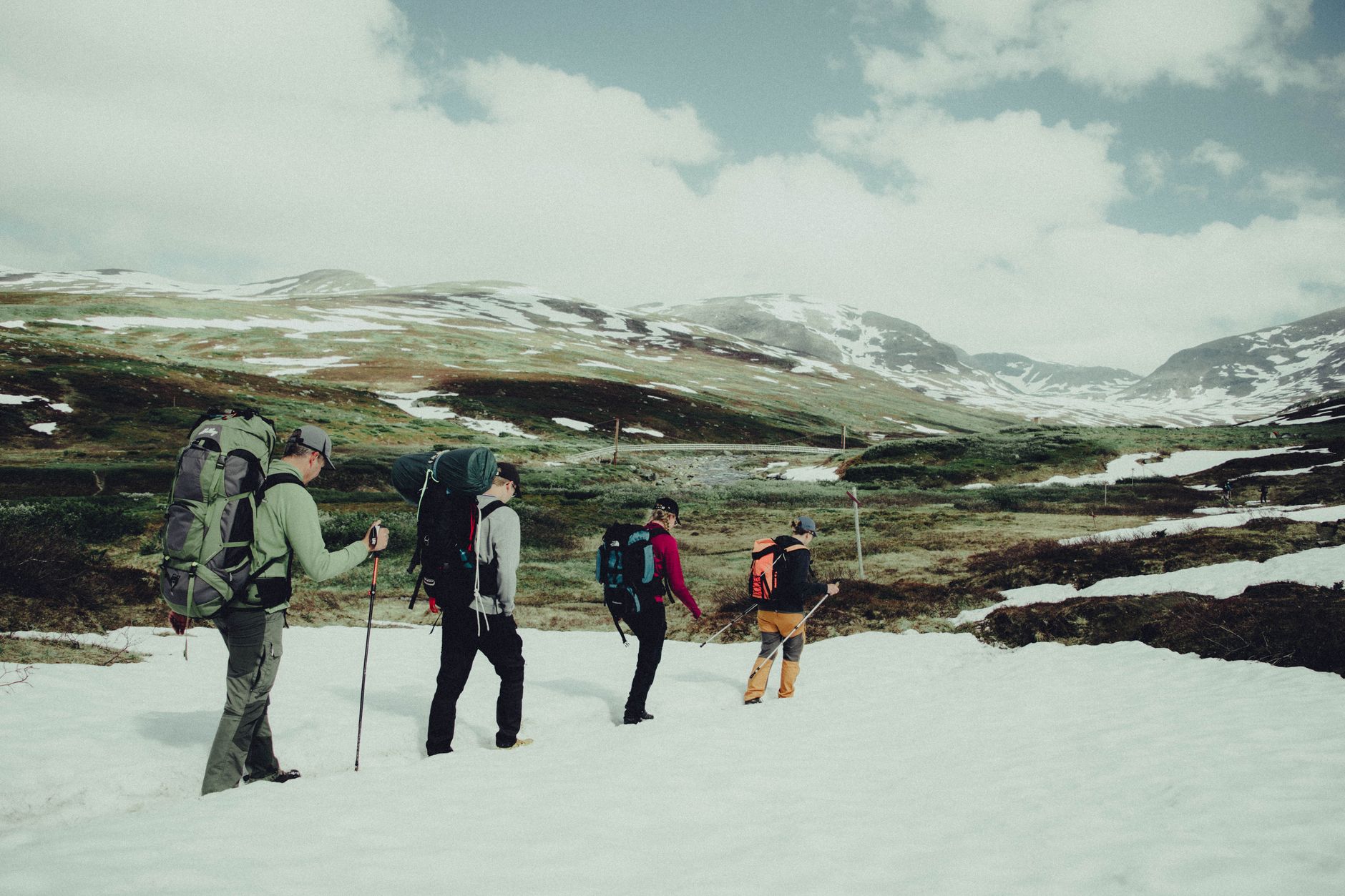 Group of hikers trekking through the snowy mountains in Sweden's natural landscape.