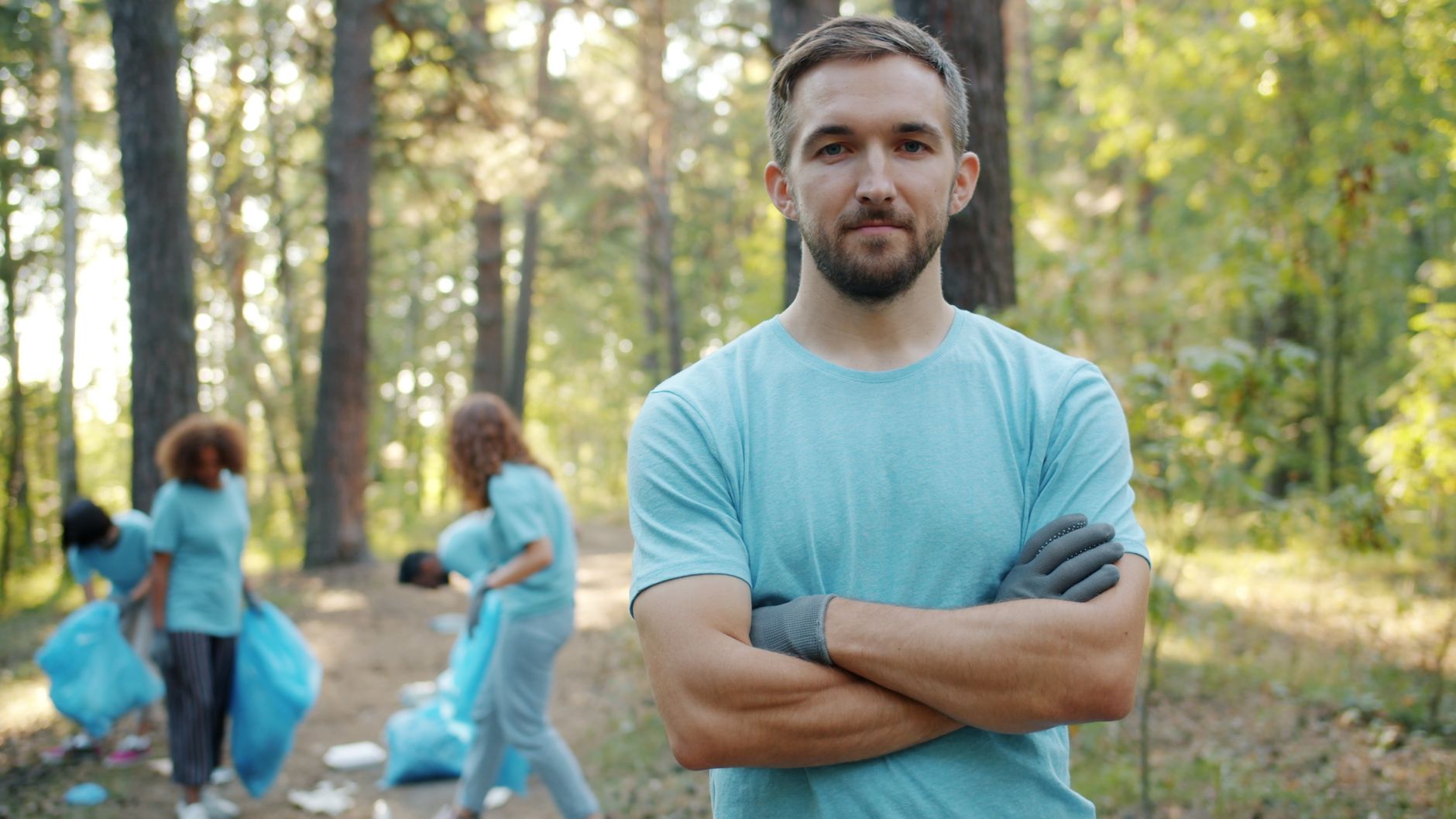 Group of volunteers cleaning a forest area, promoting environmental awareness.