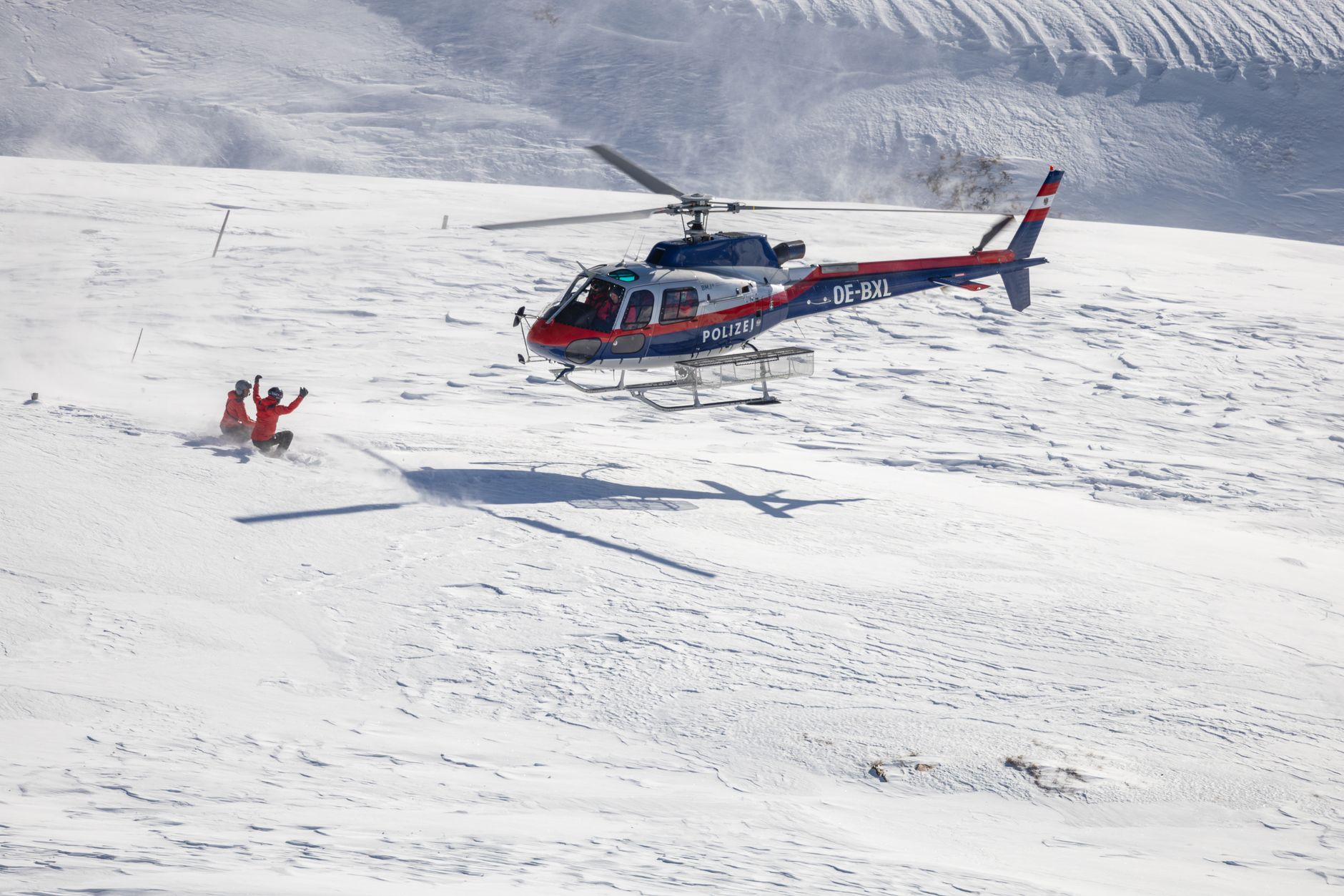 Helicopter executing a police rescue in snowy Heiligenblut mountains.