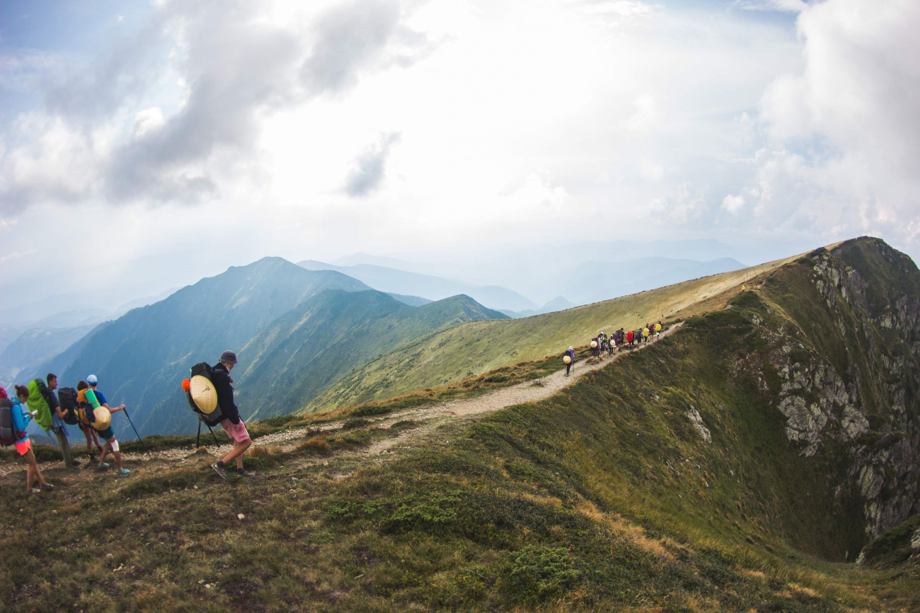A group of hikers traverses a foggy mountain ridge, capturing the serene beauty of nature.