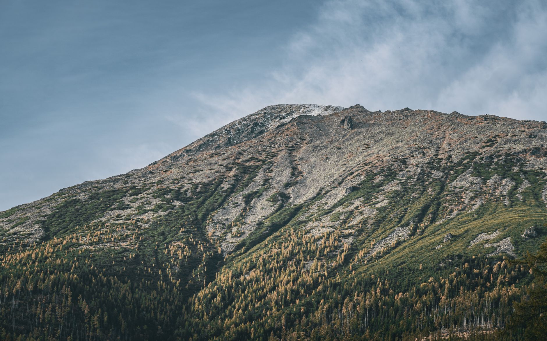 Stunning autumn landscape of Tatra Mountains, Slovakia, with vivid sky and lush foliage.