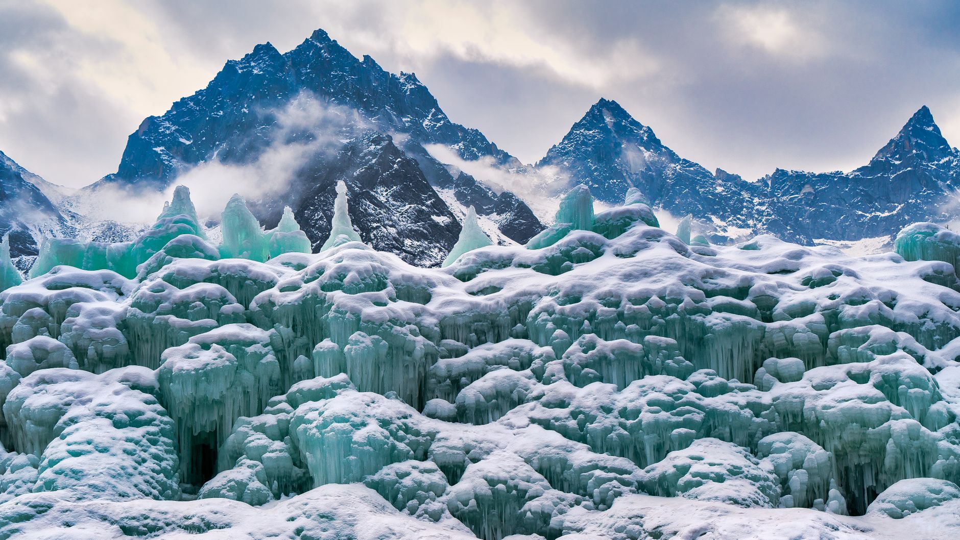 Stunning winter landscape with icy formations and snow-capped mountains.