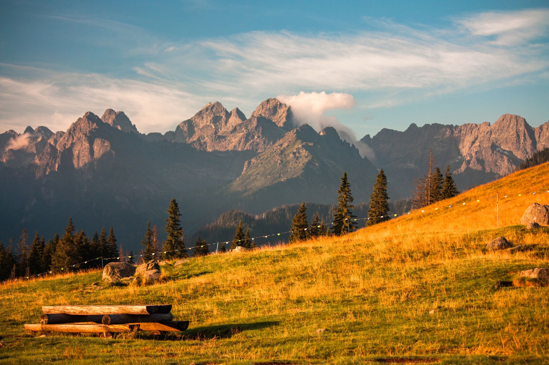 Beautiful autumn scenery of the Tatra Mountains with a wooden bench in the foreground.