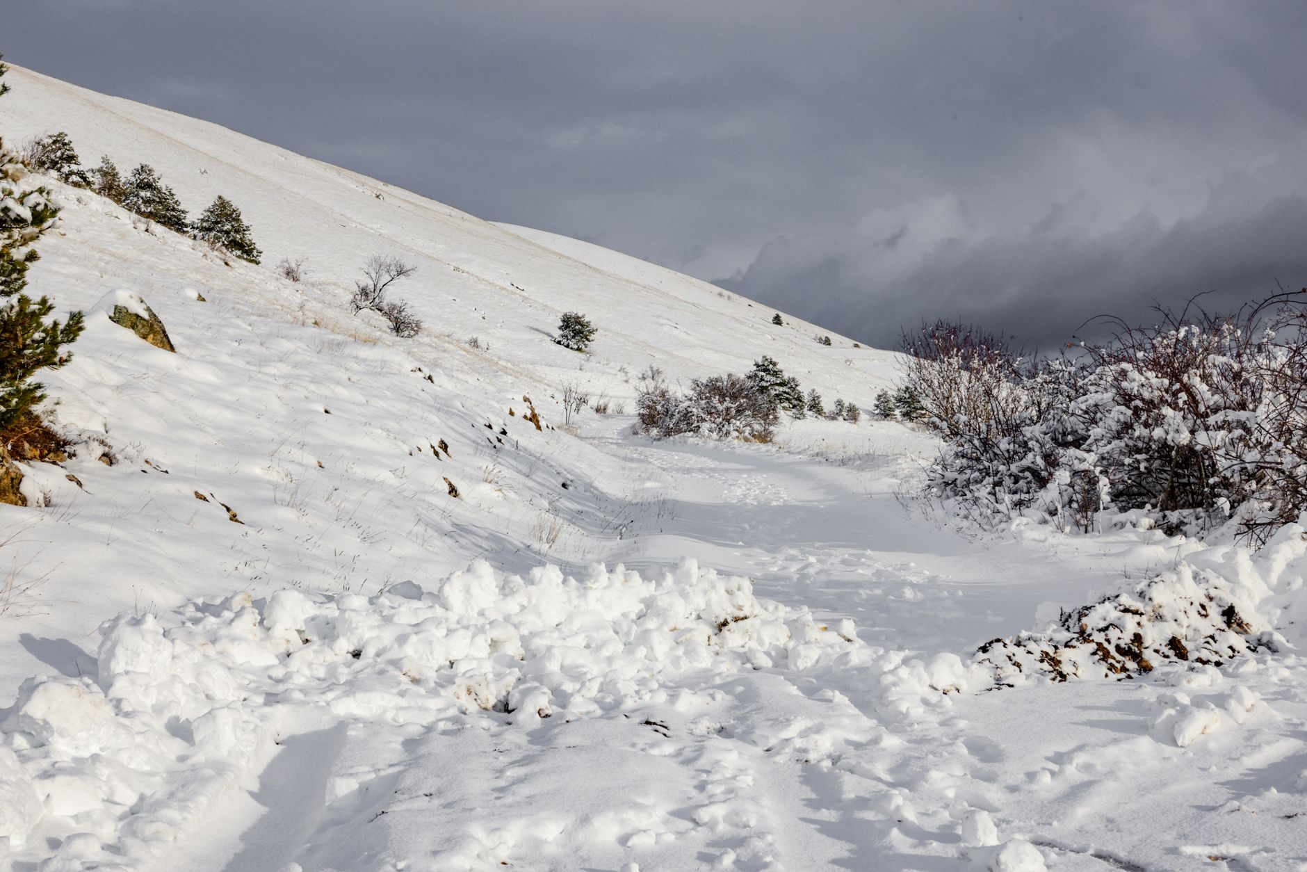 A serene snow-covered mountain landscape under a moody winter sky.
